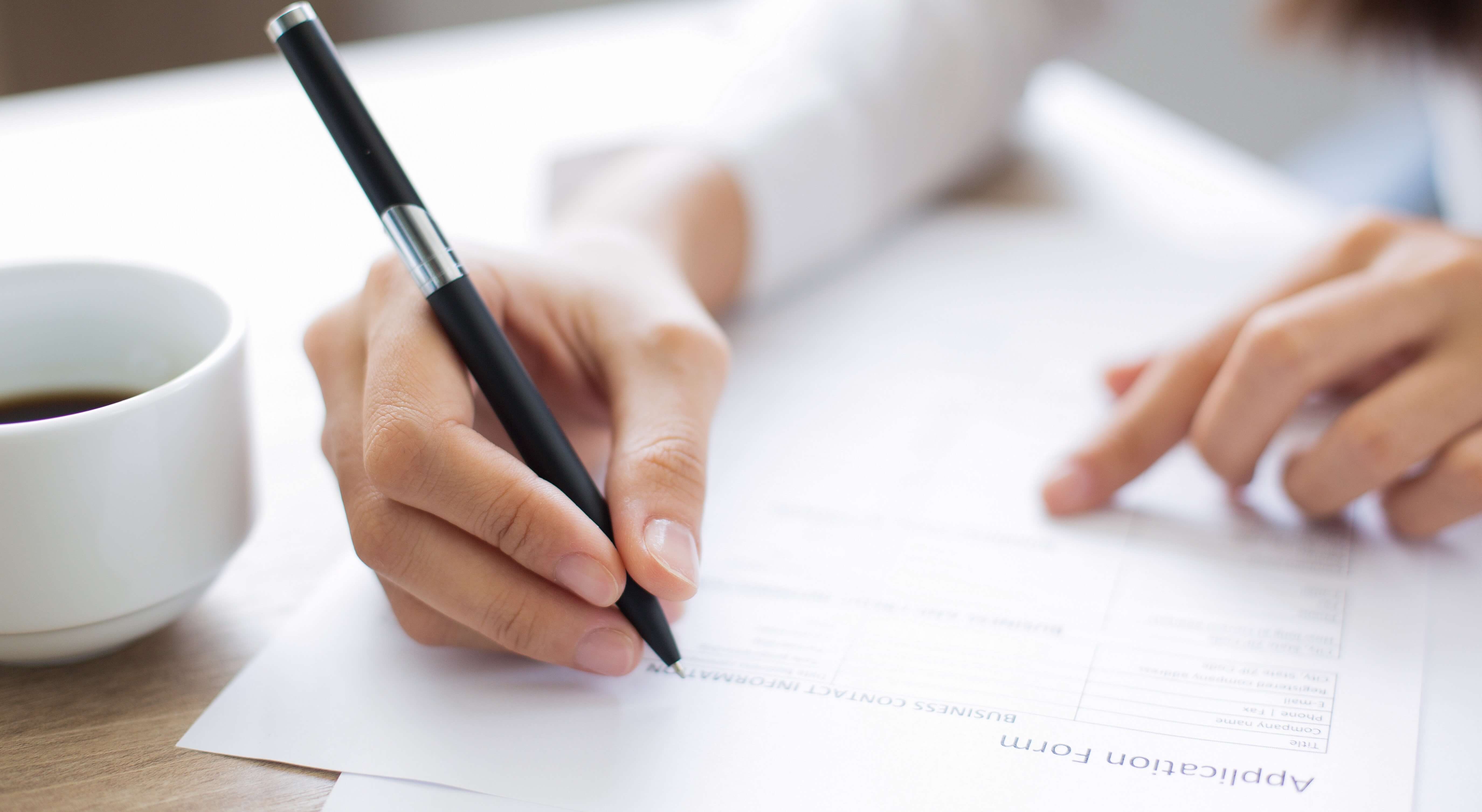 Women Filling Out Application Form For Job