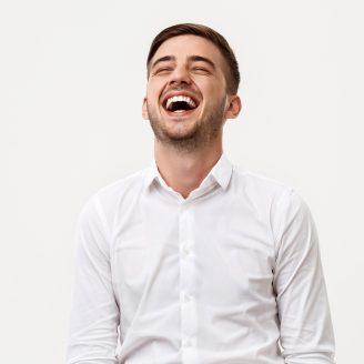 Young successful businessman smiling, laughing over white background.