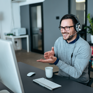 Handsome young man having online call at modern office